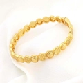 Detail van 24k vergulde armband met schubbenstructuur en sluiting op witte stof - Goudgeel