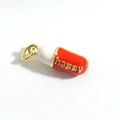 Dettaglio macro del ciondolo a capsula rosso e bianco con scritta happy e anello - Stile Capsula Testo Happy (15)