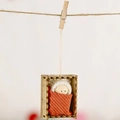 Handgefertigte Weihnachts-Holzpuppe mit orangefarbenem Strick und weißem Hut am Seil - Orange