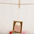 Handgefertigte Holzpuppe in rosa Cord-Wickeltuch mit einer weißen Strickmütze - Pfirsichrosa