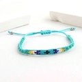 Détail d'un bracelet tissé turquoise avec des perles colorées et un cordon ajustable - Style de motif tissé vert turquoise (I)