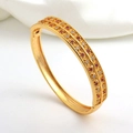 Detailed macro view of gold-plated hinged bracelet with red and white cubic zirconia - Red Zirconia Leaf Bangle