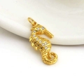 Macro shot of gold seahorse pendant with white cubic zirconia on white ceramic - Vivid Seahorse Style (08)