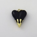 Close-up of heart-shaped pendant with black enamel top and gold dripping metal detail - Black