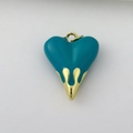Detail of a solid heart-shaped pendant with teal enamel and gold-plated metal casing - Lake Blue