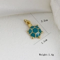 Dettaglio del ciondolo a tartaruga dorato con smalto ciano e misure di 2,2x1,1cm incluse - Tartaruga Marina Ciano (F)