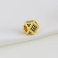 Detailed view of micro-paved black zircon gold dice charm on white silk fabric background - Dice Style A