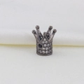 Macro detail of gunmetal crown bead with pavé zircon crystals on white silk background - Crown B