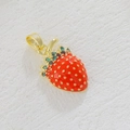 Macro view of gold-plated strawberry pendant with red enamel and green zircon accents - Strawberry with Crystals (05)