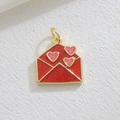 Macro detail of a red gold-plated envelope pendant with pink glitter hearts for DIY jewelry - Red Glitter Envelope(03)