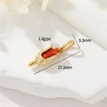 Macro view of corn-shaped 18k gold plated pendant with red beads on a stone base - Gold Corn Pendant (41)