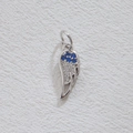 Silver wing pendant with blue and white zircons on beige leather background - Silver Blue Gemstone Wing (5867416729801)