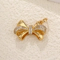 Detailed view of a gold bow pendant with sparkling cubic zirconia on textured surface - Bowknot Micro-set Petals (21)