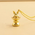 Macro shot of gold rabbit pendant in hat with sparkling crystals on a beaded chain - Magic Rabbit with Lucky Bag (08)