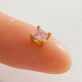 Vue macro d'un minuscule clou d'oreille carré en zircon rose sur le bout d'un doigt - Strass Carré Rose-Or (15)