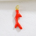 Detail of a bright red coral branch pendant with a gold ring for DIY jewelry making - Red Coral