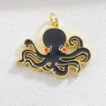 Detailed view of octopus charm with black enamel and red accents on gold-plated metal - Black Octopus