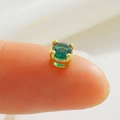 Macro view of a tiny emerald green round gemstone in a gold four-claw setting - Green Round Rhinestone-Gold (03)