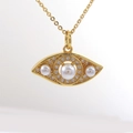 Primer plano del colgante de ojo chapado en oro con perla central y circonitas pavé - Estilo Ojo de Oliva de Tres Perlas (01)