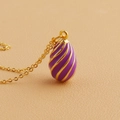Macro detail of purple enamel egg pendant necklace with gold spiral texture lines - Purple