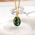Detail showing dark green enamel egg pendant with 18k gold plating and crystals - Green