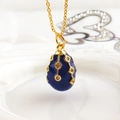 Macro shot of Fabergé style dark blue enamel egg pendant with gold diamond patterns - Dark Blue