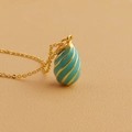 Macro detail of 18k gold plated necklace with blue enamel egg pendant and spiral design - Lake Blue