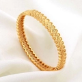 Detail van een 24K vergulde opengewerkte armband met hartpatronen en kleine kristallen - Goudgeel