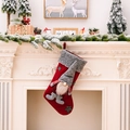 Roter Weihnachtsstrumpf mit grauer Wichtelfigur an einem klassischen weißen Kamin hängend - Rot