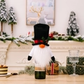 Christmas gnome wine bottle cover with red plaid hat and white beard on a festive table - Top Hat Snowman