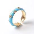 Détail macro d'une bague en émail bleu ciel avec motifs floraux dorés et zircons colorés - Ouvert Réglable / Bleu ciel