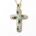 Close-up of gold cross pendant with white enamel and turquoise evil eye details - White Enamel Turquoise Border Cross (04)