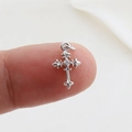 Macro detail of a silver cross pendant with clear zircon inlay held on fingertips - Silver Relief Rhinestone (8)