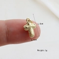 Detailed view of a small golden cross pendant measuring 1.6cm by 0.9cm and weighing 1g - Gold Mirror (11)