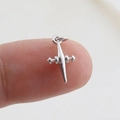 Close-up of small silver cross pendant charm being held to show miniature size - Silver Geometric (18)