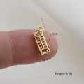 Macro shot of a mini golden abacus pendant measuring 1.7cm by 0.8cm on a fingertip - Gold Abacus Style (03)
