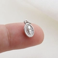 Macro di un ciondolo a conchiglia d'argento sulla punta del dito per scala dimensionale - Stile Rilievo Conchiglia Argento(04)