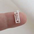 Miniature silver abacus pendant charm shown on fingertip to display its small size - Silver Abacus Style (04)