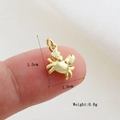 Dettaglio di un ciondolo a forma di granchio dorato per mostrare la misura piccola di 1,5 cm - Stile Forma Granchio Oro(02)
