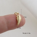 Detailed view of a gold feather pendant showing dimensions 1.7cm by 0.6cm on a finger - Gold Feather Style (8)