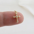 Detailed view of a gold cross pendant with white zircons held by fingers for size reference - Gold 5 Rhinestones Symmetric (24)