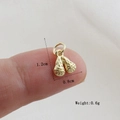 Macro shot of small golden woven pendant on fingertip showing 1.2cm x 0.8cm size - Gold Lacrosse Stick Style (9)