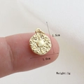 Detailed view of a 1.0cm gold-plated round sunburst charm shown for size on a fingertip - Gold Solar Pattern Style(11)