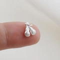 Macro shot of silver lacrosse stick pendant charm on a fingertip for size scale - Silver Lacrosse Stick Style (10)