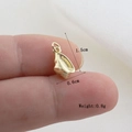Macro shot of small golden conch shell pendant showing 1.5cm height and fine textures - Gold Mini Conch Style(13)