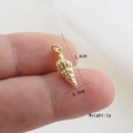 Detailed macro view of a 1.8cm golden conch pendant showing texture and size in hand - Gold Spiral Conch Style(15)