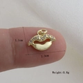 Dettaglio macro di un ciondolo a forma di labbra dorate da 1,3 cm con zirconi bianchi sulle dita - Stile Zirconia Bianca Forma Labbra Oro (23)