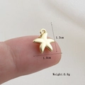 Detail of a 1.3cm gold starfish pendant showing dimensions and scale on a finger - Gold Starfish Style(19)