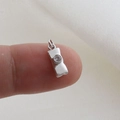Macro shot of tiny silver padlock charm with zircon inlay held on a fingertip - Silver Bezel Setting Style (20)