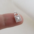 Close-up of silver padlock charm with micro-paved crystals and heart detail on fingertip - Silver Heart Lock Style (22)